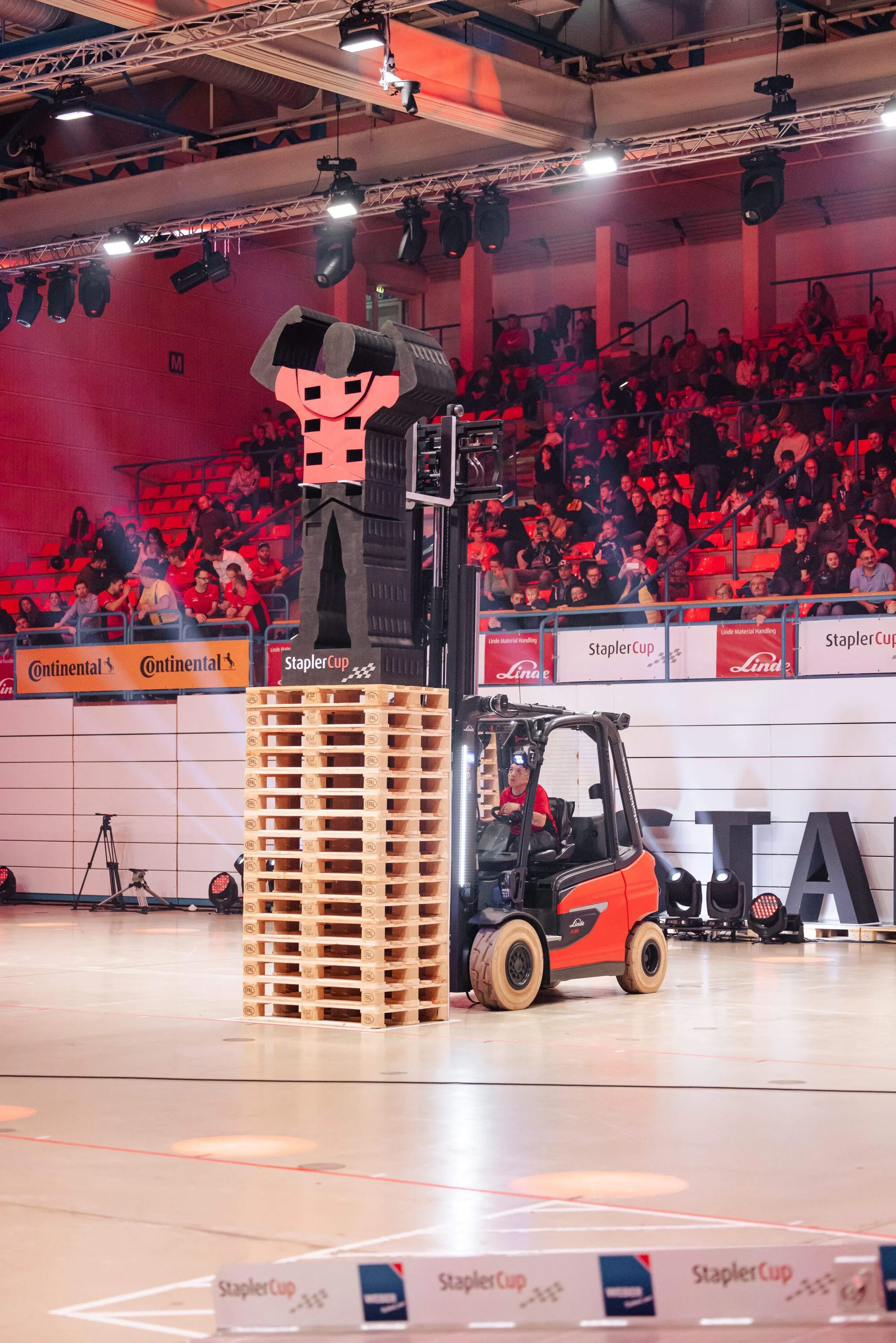 A forklift next to a tower of pallets in the packed StaplerCup arena