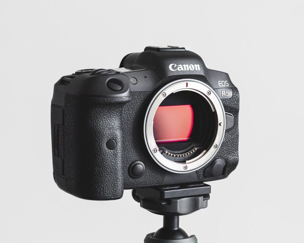 Canon r5 camera on a tripod in front of a white wall