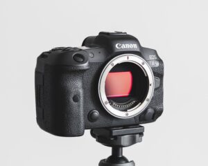 Canon r5 camera on a tripod in front of a white wall
